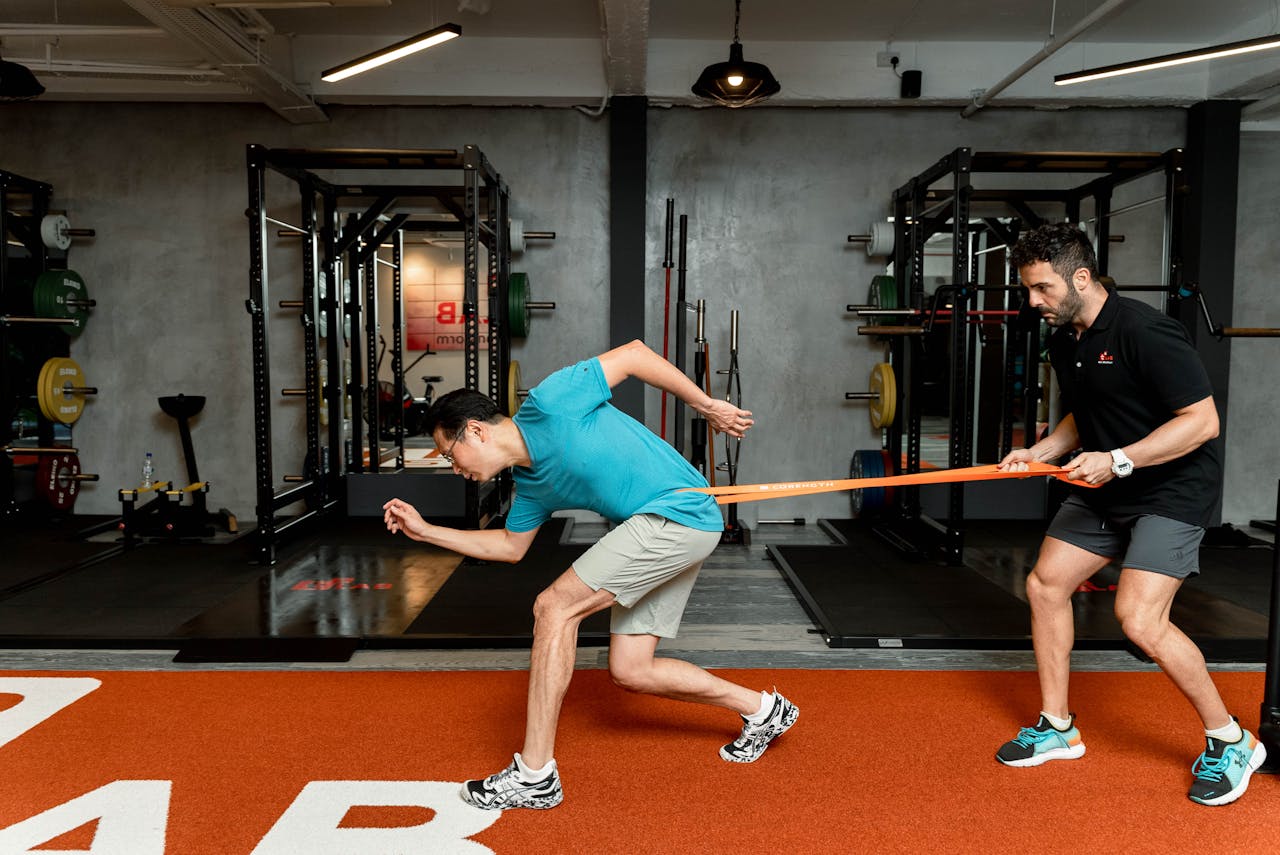 Adrien guidant un sportif lors d’un exercice avec un élastique